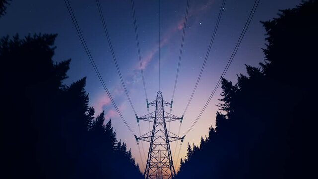 High voltage electricity pylons in a night forest. Starry sky in the background