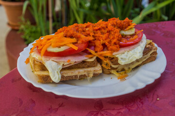 Meal in Bosnia and Herzegovina. Toasts with vegetables, ham, egg, cheese and ajvar