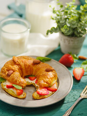 A beautiful composition - a table set for breakfast for one person - croissant, milk, decor. Macro photography. Menu design, culinary blog, cookbook, advertisement, banner, invitation.