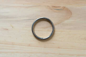 metal ring on a wooden surface - obrazy, fototapety, plakaty