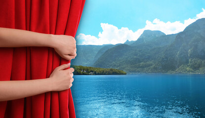Woman opening red front curtain and picturesque view of river and mountains on background - obrazy, fototapety, plakaty