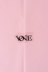the word "love" in black type isolated on pink paper