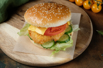 burger with chicken on a wooden board