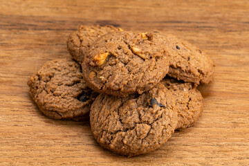 Pile of delicious chocolate chip butter cookies on wooden table. Group of dessert snack, cookies, pile on wooden table.