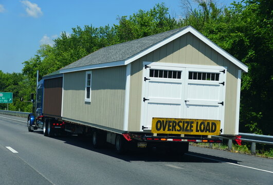 Virginia, U.S.A - August 21, 2021 - A light color trailer house marked oversize load hauled on a truck