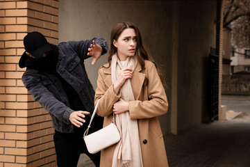 Thief trying to steal woman's bag in alley. Self defense concept