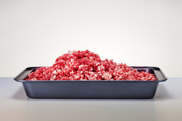  Tray with raw chopped meat on the kitchen table.