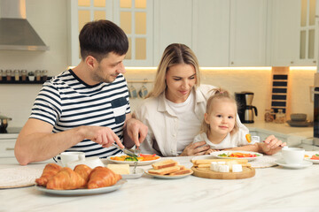 Obraz na płótnie Canvas Happy family having breakfast together at table in kitchen