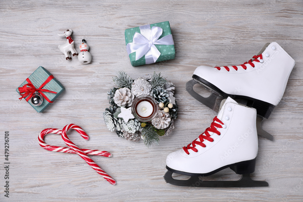 Wall mural Pair of ice skates, Christmas decor and gift boxes on white wooden background, flat lay