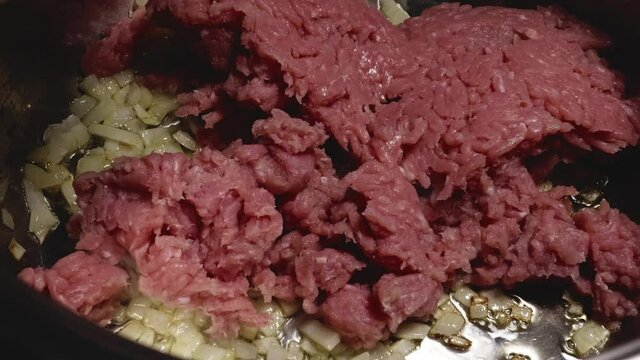 Person is Adding Minced Turkey Meat to a Saucepan, Chopped Onions are Saut&eacute;ed in Pan - Steady Shot