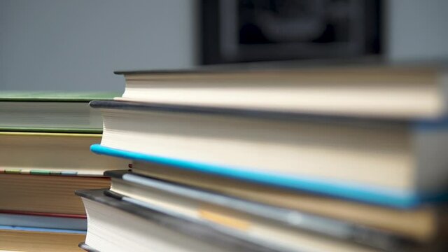 Close up front of books lying on a stack - slide camera