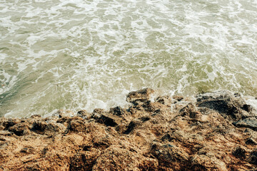 Sea waves hit the shore rocks.