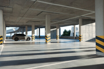 Open parking garage with car on sunny day - obrazy, fototapety, plakaty