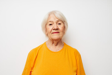 Cheerful elderly woman in casual t-shirt gestures with his hands cropped view