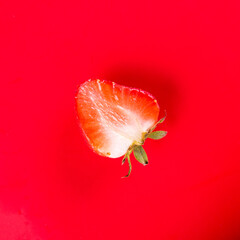 Half strawberry on red background isolated top view, copy space