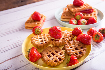 Vienna waffle muffins with strawberries and jam on a plate, side view, copy space