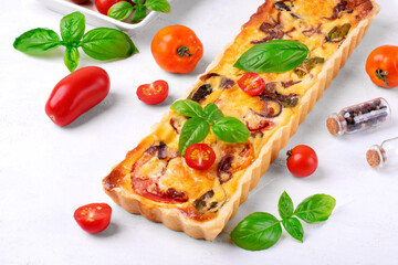 Quiche with egg, tomato, caramelized onion, basil and cheese. French cuisine pie
