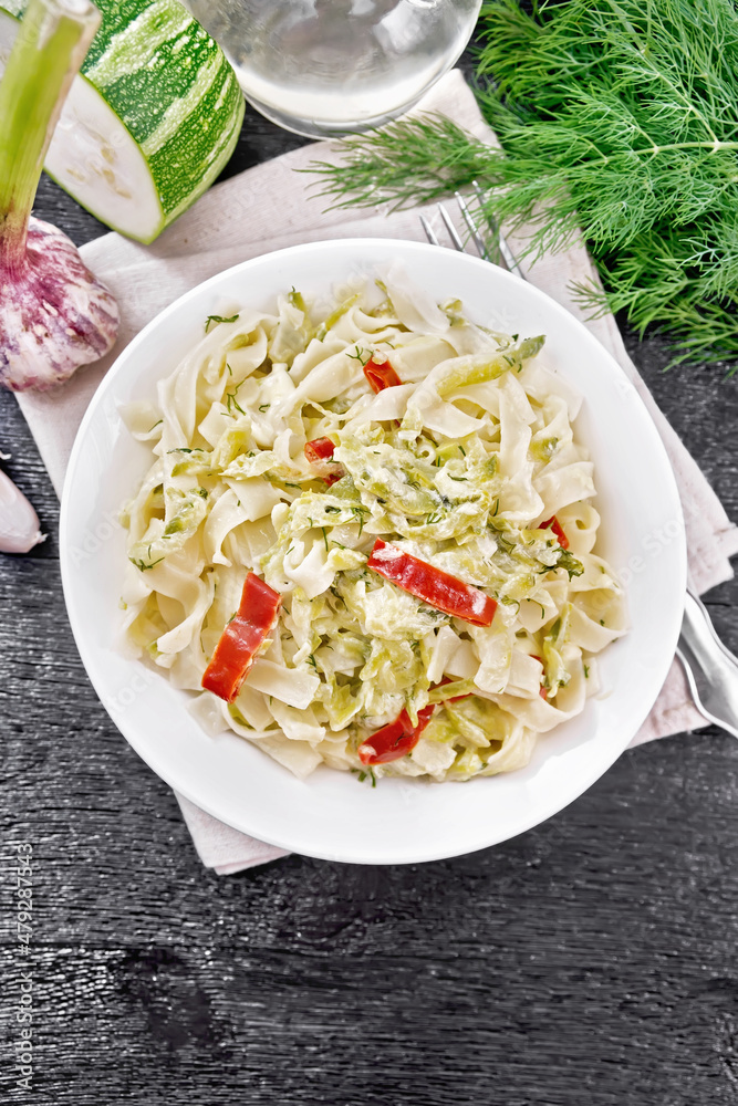 Wall mural Fettuccine with zucchini and hot peppers in plate on dark board top