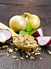 Onion flakes in spoon on board