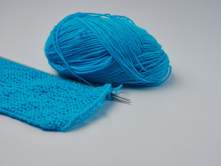 Wool yarn in different colors with wooden double point needles. The needles are being used for knitting socks, mittens or other projects joined in the round.