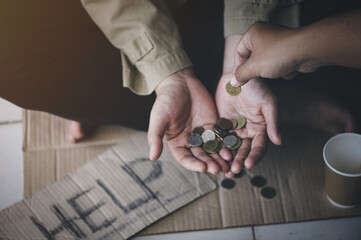 Closeup of men giving money to poor or homeless people poverty beggar in the city sitting on the...