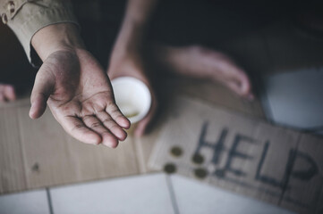 Closeup of  poor or homeless people poverty beggar in the city sitting on the streets with a sign for help