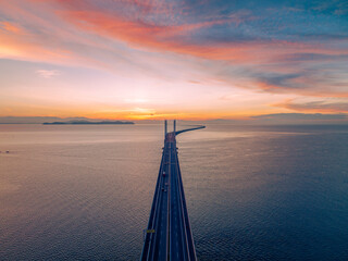 View of the bridge at sunrise which stands on the sea and connects the island and the mainland. It is the longest bridge in Malaysia