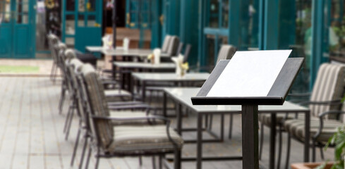 blank food menu on wood podiuem front of outdoor restaurant