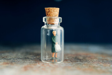 Obraz na płótnie Canvas miniature figurine of a woman inside a mini glass bottle