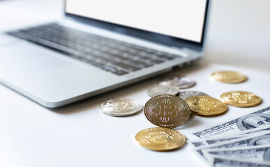 Focus on silver coin, dollar and computer laptop with blank screen on white background. Concept invest in cryptocurrency