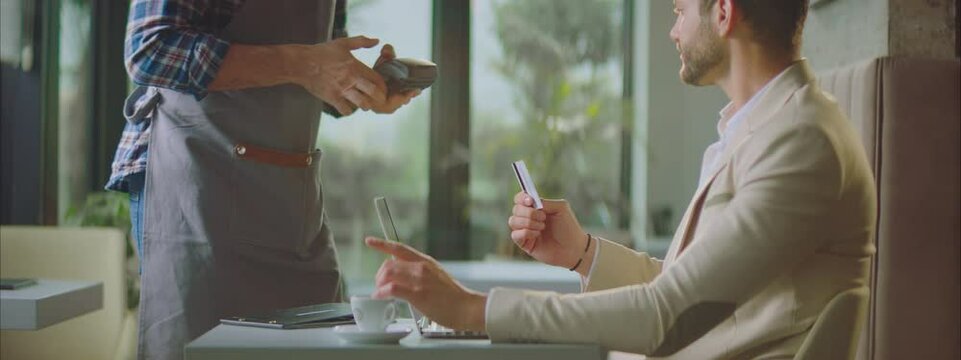 Man using credit card for paying bill in restaurant or cafe. Contactless payment method. Entrepreneur working outside office.