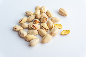 Pistachio nuts isolated on white background. A pile of salted roasted pistachios- an excellent source of protein, antioxidants, and fiber.