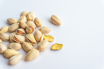Pistachio nuts isolated on white background. A pile of salted roasted pistachios- an excellent source of protein, antioxidants, and fiber.