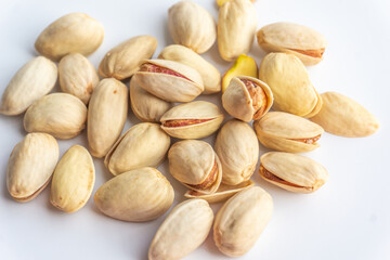 Pistachio nuts isolated on white background. A pile of salted roasted pistachios- an excellent source of protein, antioxidants, and fiber.