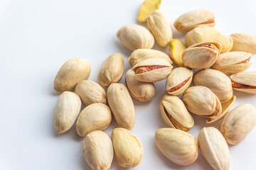Pistachio nuts isolated on white background. A pile of salted roasted pistachios- an excellent source of protein, antioxidants, and fiber.