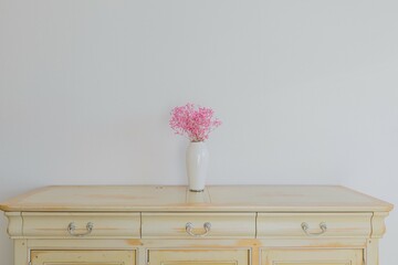Pink flower in vase standing on dresser