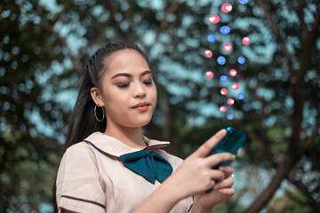 A young asian senior high school student chats or browses her social media feed on the phone while...
