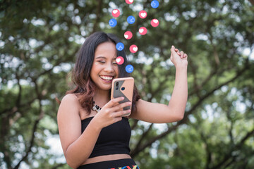 A pretty Filipina woman celebrates upon seeing great news on her phone. Receiving a notification...