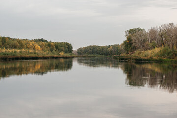 Fototapeta na wymiar autumn, a calm lake with a bank of yellow trees