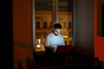 Enthusiastic young specialist work overtime to impress employer. Freelancer programmer use laptop...