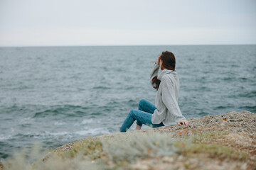 Naklejka na ściany i meble pretty woman sweaters cloudy sea admiring nature Relaxation concept