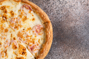 Pizza with cheese on a dark background. Copy space.