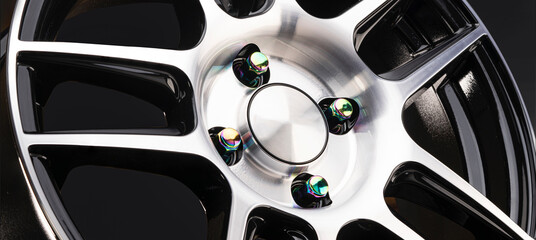 wheel nuts for alloy wheel yellow or green, iridescent close-up on an aluminum disc panoramic photo