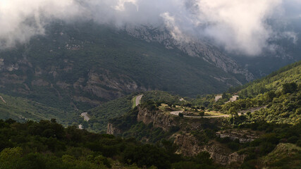 Fototapeta premium Beautiful view of mountain range Massif de la Sainte-Baume in Provence, France on cloudy day in autumn with winding country road D2 and rocks.
