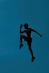 Fototapeta na wymiar Side view of black serious sportsman jumping