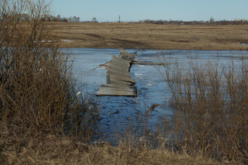 Ice drift, debacle. Old broken wooden bridge over the canal. Extreme crossing the river....