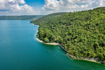 Aerial view of Bakotinskaya bay, Ukraine, scenic view of the Dniester river, rocks, forests and mountains above the blue water of the lake, sunny day