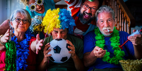 Group of football fans at home enjoy and exult for team success - world championship 2022 television concept - family watching soccer on television at home and have fun together in friendship