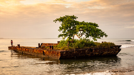 Sunset on a wreck of a barge on the Caribbean coast of Costa Rica in Puerto Viejo