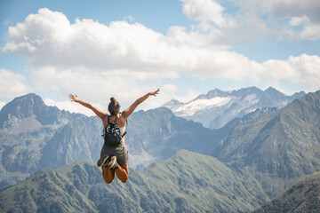Jeune femme qui saute devant les montagne, symbole de liberté